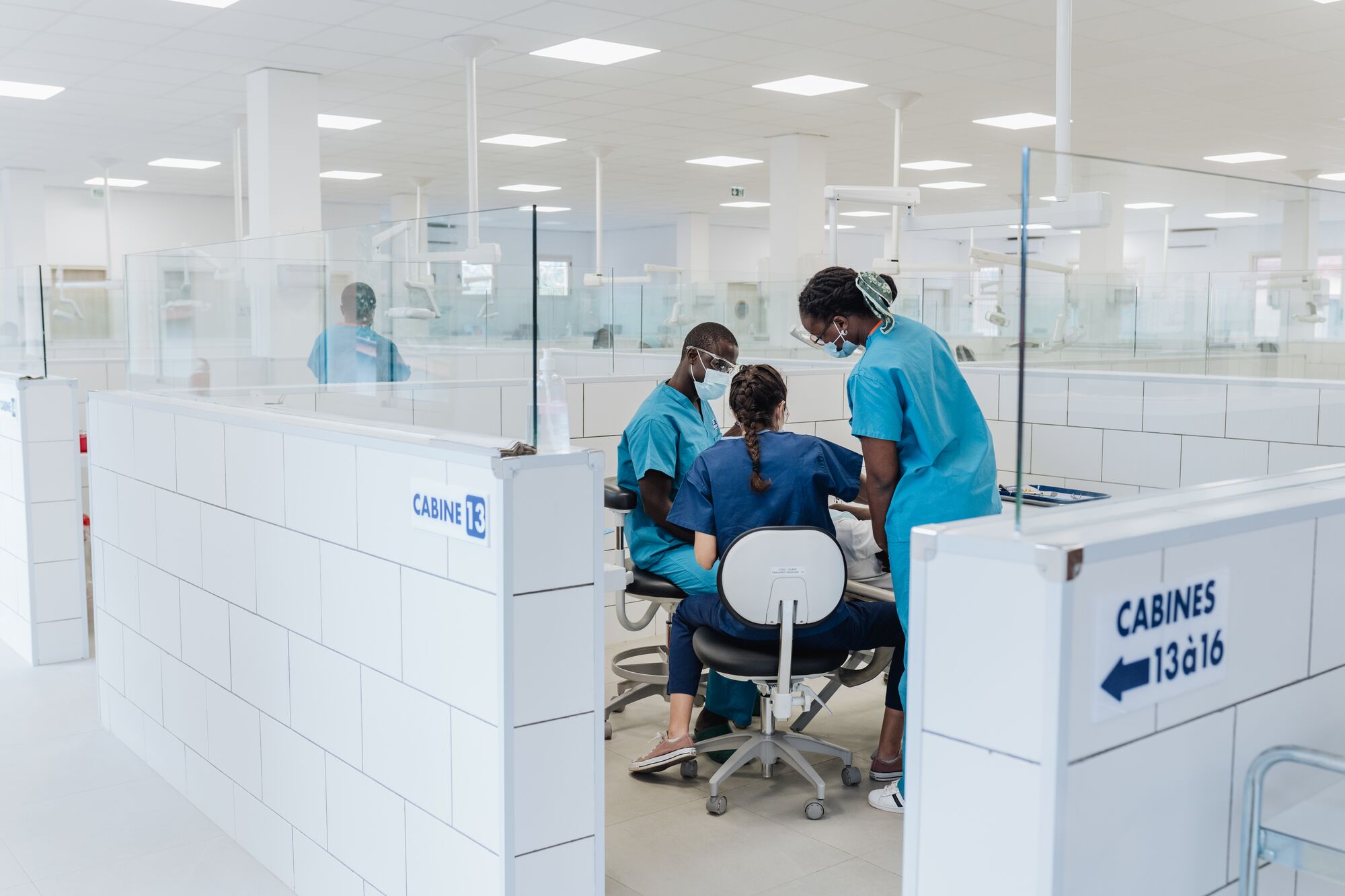 Ruth Catraye, Ana Filipa, and another dental student treat a patient in the new clinic at University of Gamal Abdel Nasser de Conakry Dental School.