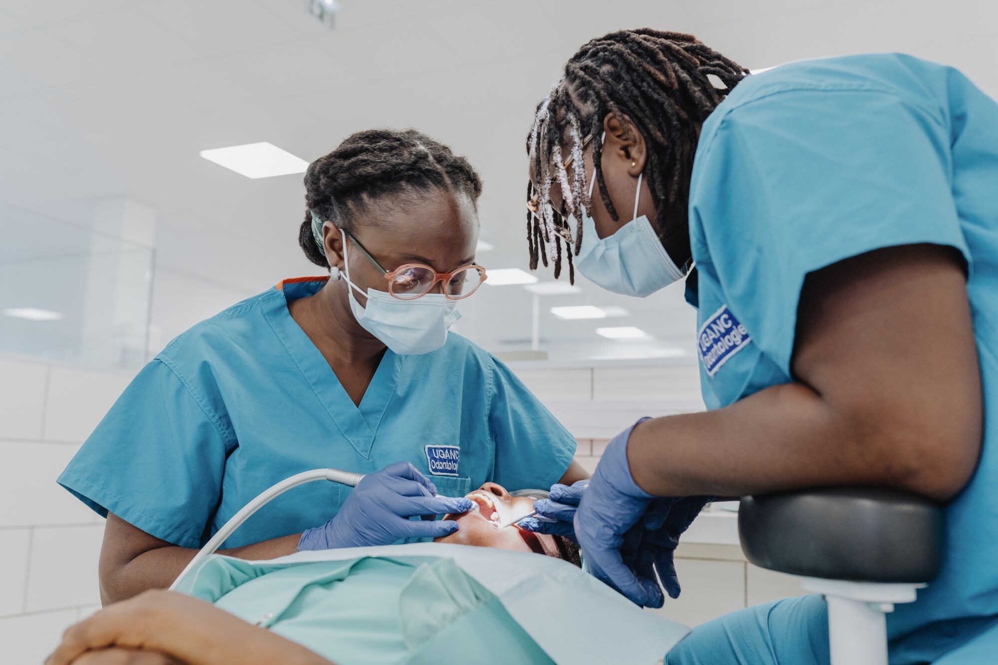 Dr. Ruth Catraye, and a UGANC Dental School staff member treat a patient in the newly finished clinic.